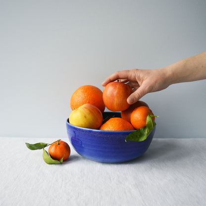 Porcelaine fabriquée en France, petit saladier bleu rempli de fruits sur fond blanc