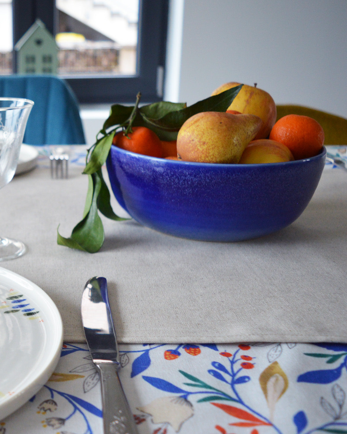 Porcelaine fabriquée en France, petit saladier bleu rempli de fruits sur une table dressée Maison Primavera