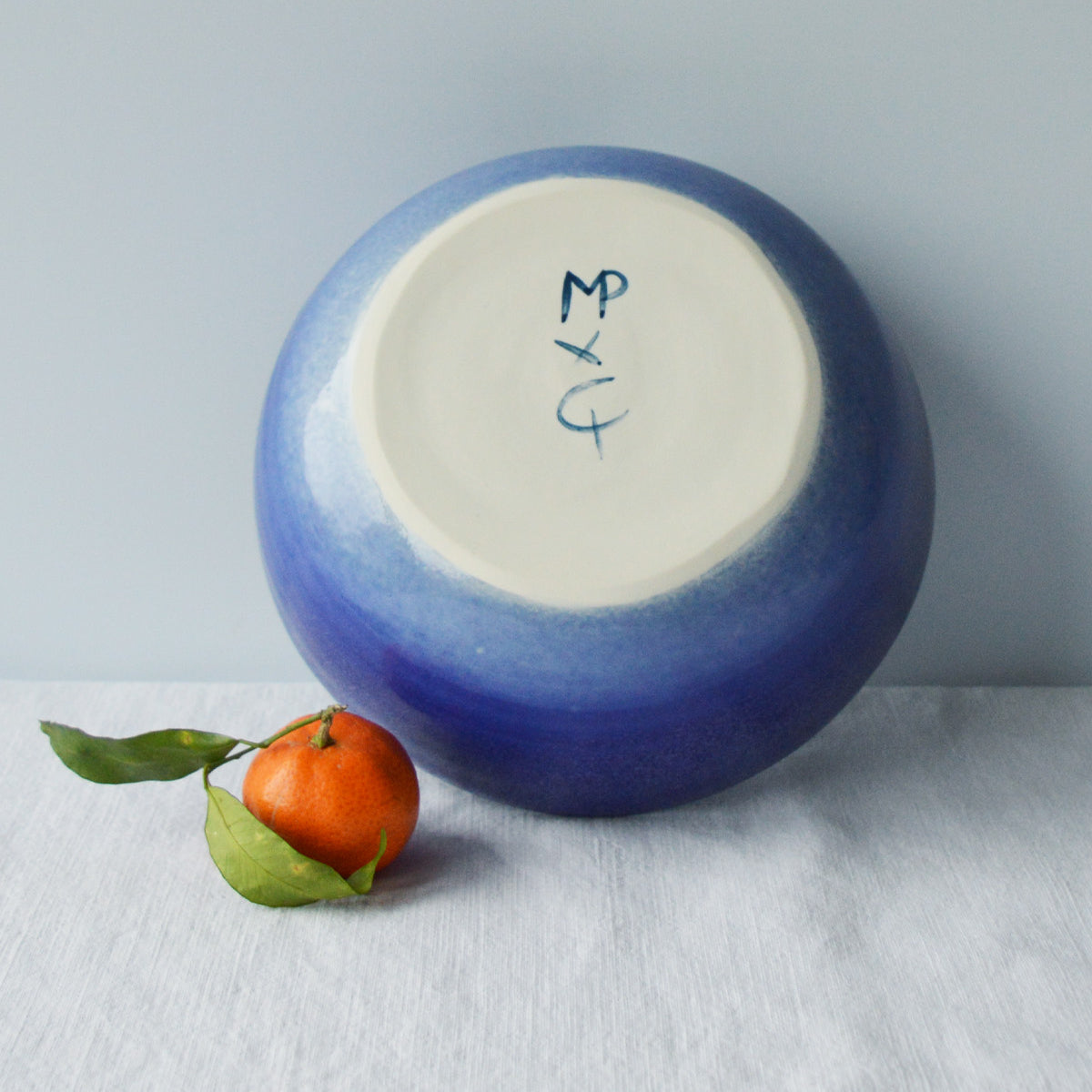 Porcelaine fabriquée en France, dos de petit saladier bleu sur fond blanc