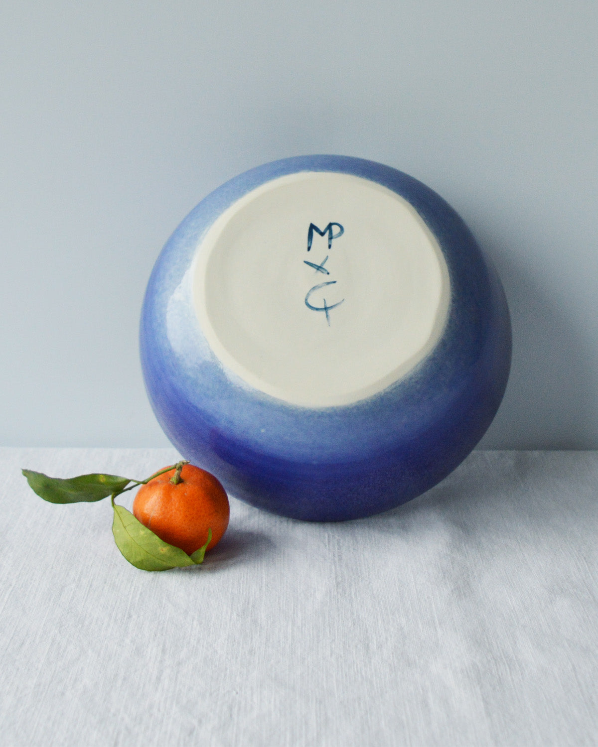 Porcelaine fabriquée en France, dos de petit saladier bleu sur fond blanc