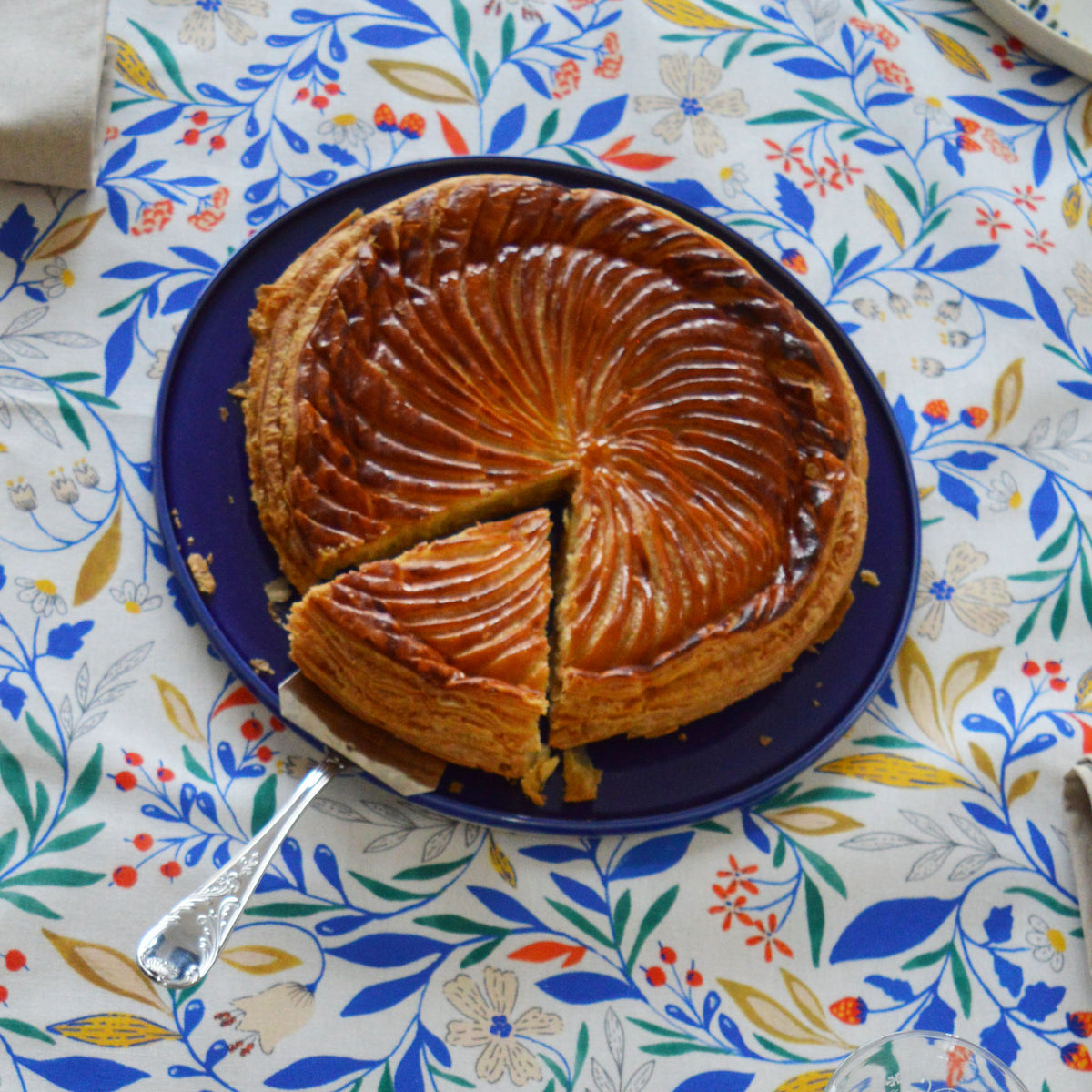 Porcelaine fabriquée en France, plat de service bleu sur une nappe à motif Primavera.