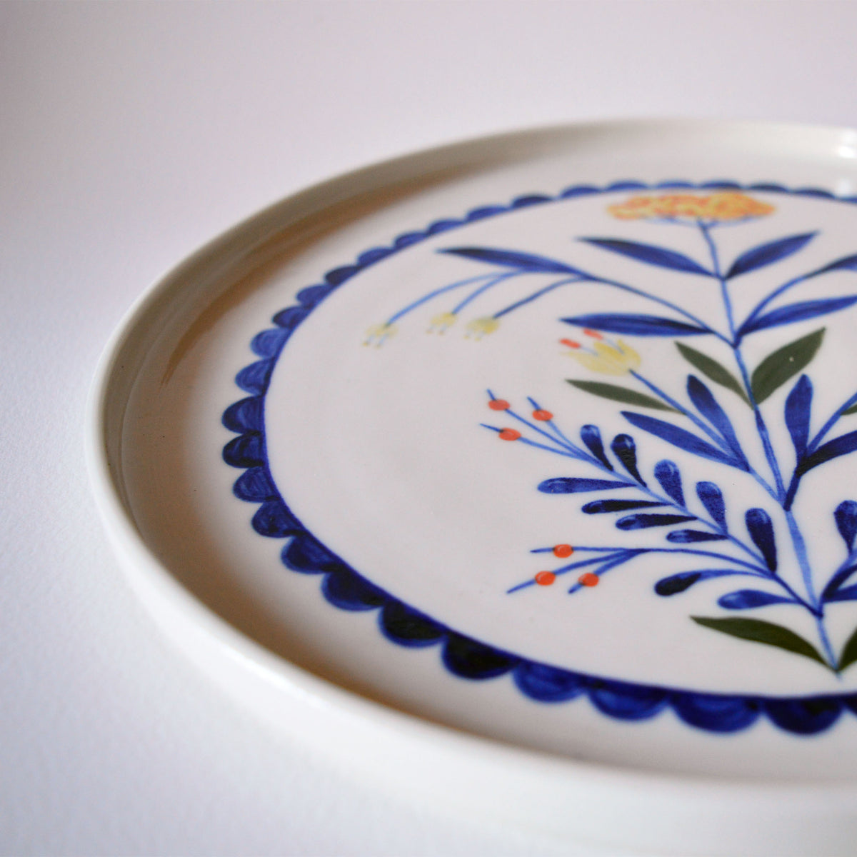 Plat moyen en porcelaine, fabriqué en France artisanalement, motif floral et coloré