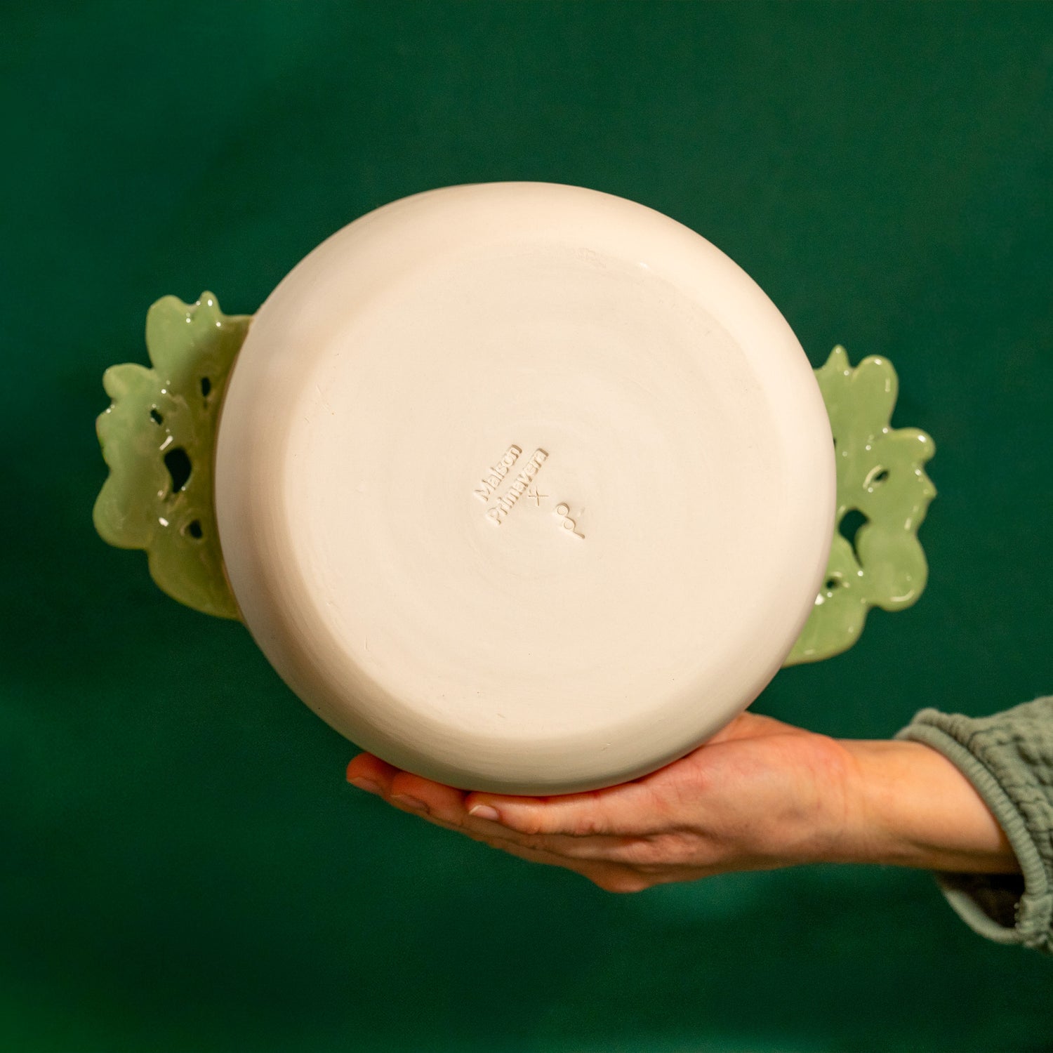 Dos d'un saladier fabriqué en France en porcelaine, artisanal, avec deux anses vertes motif cœur alsacien