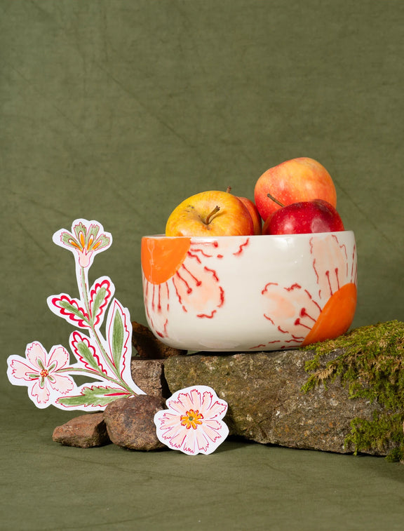 Saladier en porcelaine artisanal fabriqué en France, motif de fleurs des champs oranges et roses, rempli de pommes