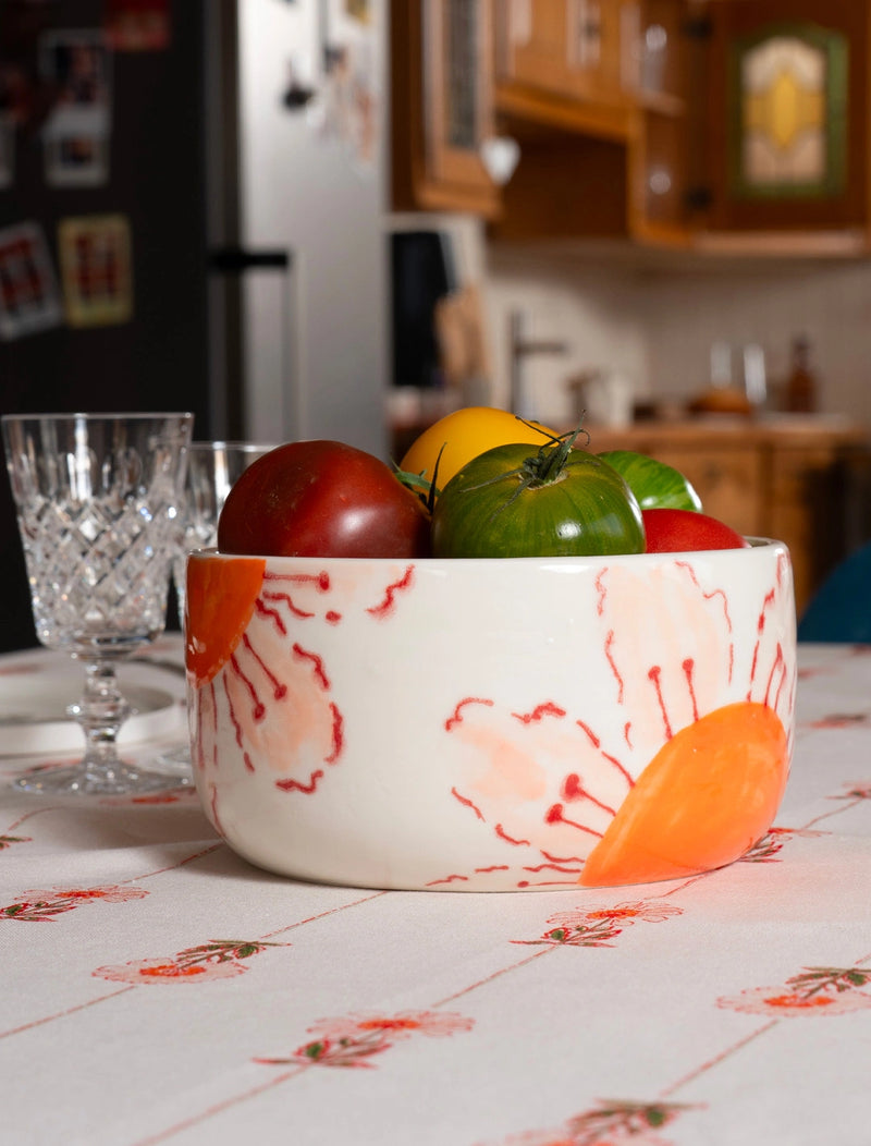 Saladier en porcelaine artisanal fabriqué en France, motif de fleurs des champs oranges et roses, sur nappe en coton et lin à motif