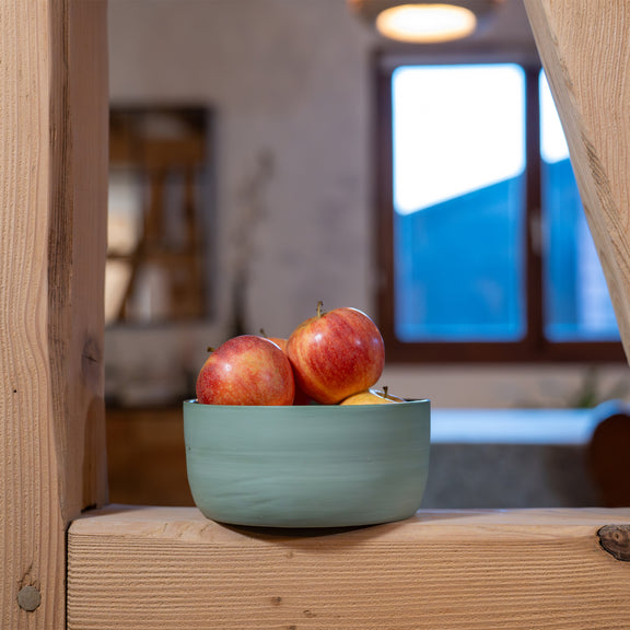 Saladier vert fabriqué en France en porcelaine, artisanal, rempli de pommes sur poutre maison colombages Alsace