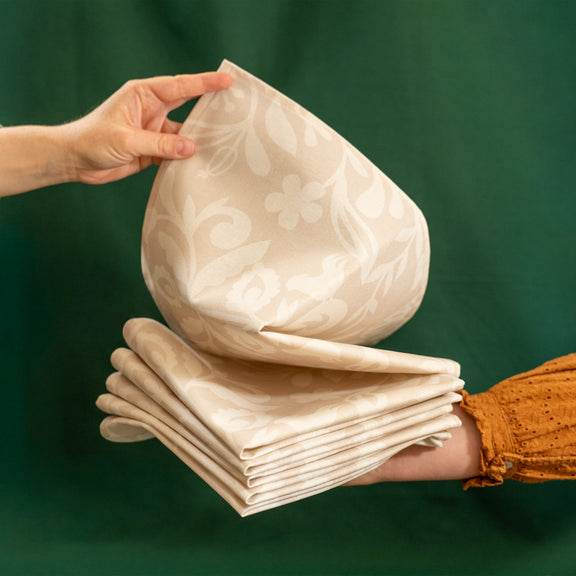 Pile de serviettes de table beiges et blanches, fabriquées en France, en coton et lin, motif floral, arbre de vie alsacien
