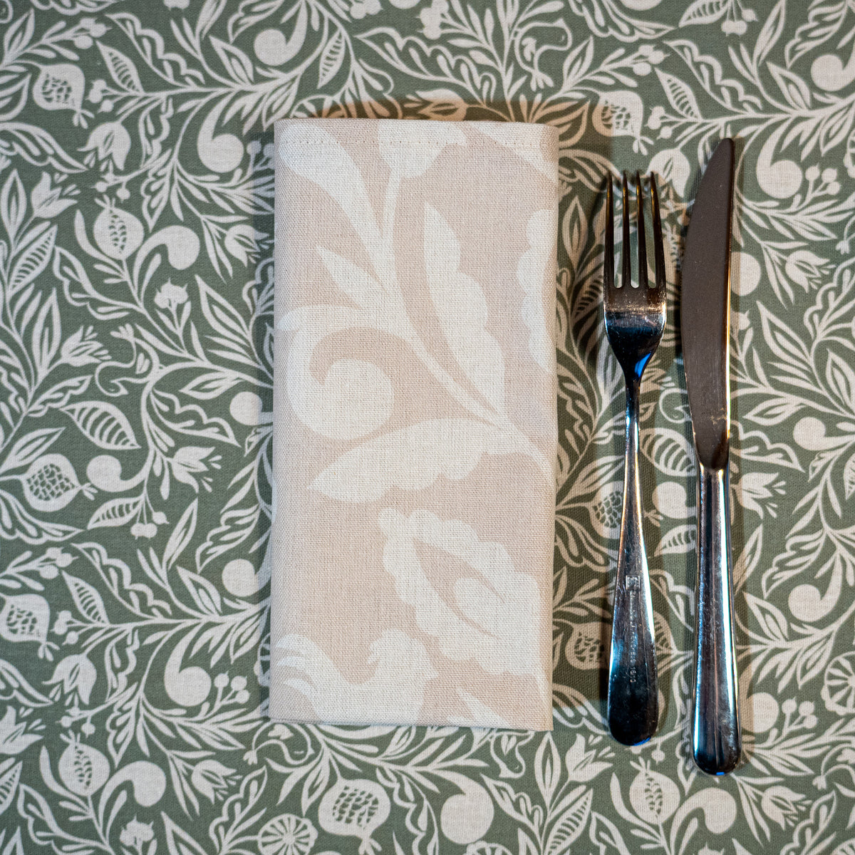 Serviette de table beige et blanche, fabriquée en France, en coton et lin, motif floral, arbre de vie alsacien, sur nappe made in France