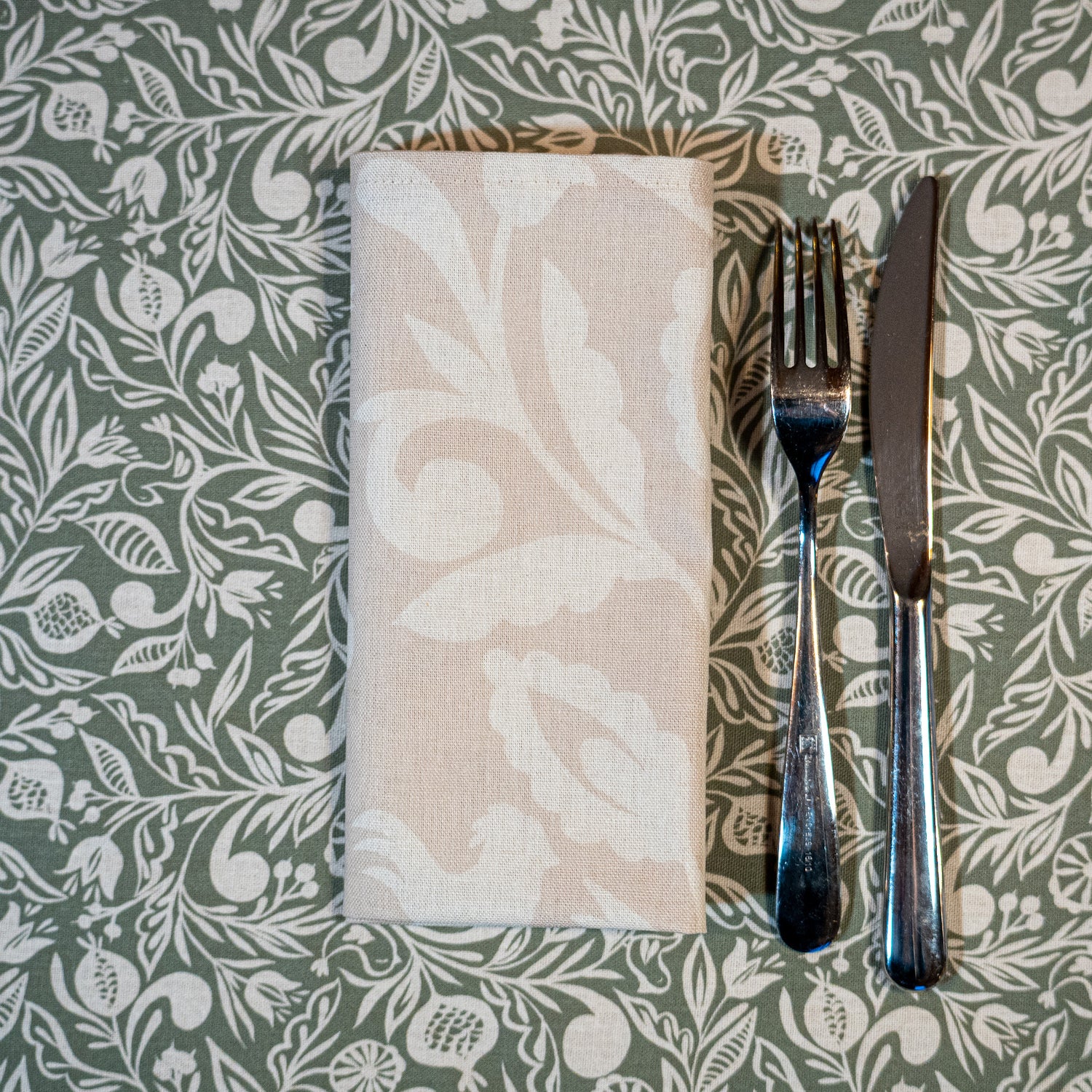 Serviette de table beige et blanche, fabriquée en France, en coton et lin, motif floral, arbre de vie alsacien, sur nappe made in France