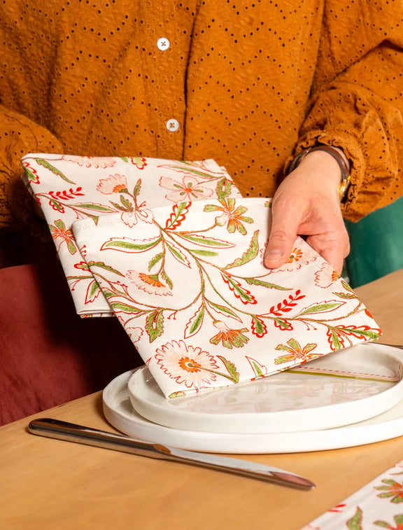 Serviette de table en coton et lin fabriquée en France avec un motif de fleurs des champs, sur des assiettes artisanales
