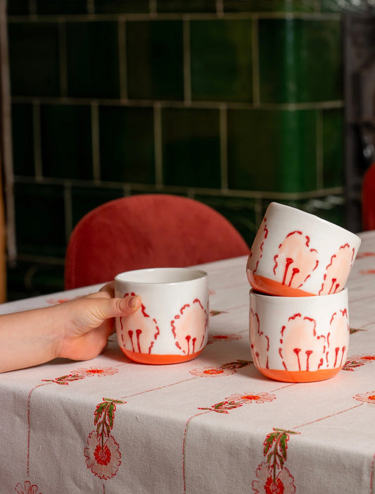 3 tasses à café en porcelaine fabriquées en France, motif de pétales de fleur des champs, sur nappe en coton et lin