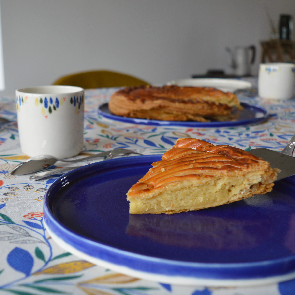 Porcelaine fabriquée en France, tasse à café à motif Primavera avec assiette bleue sur table dressée Primavera