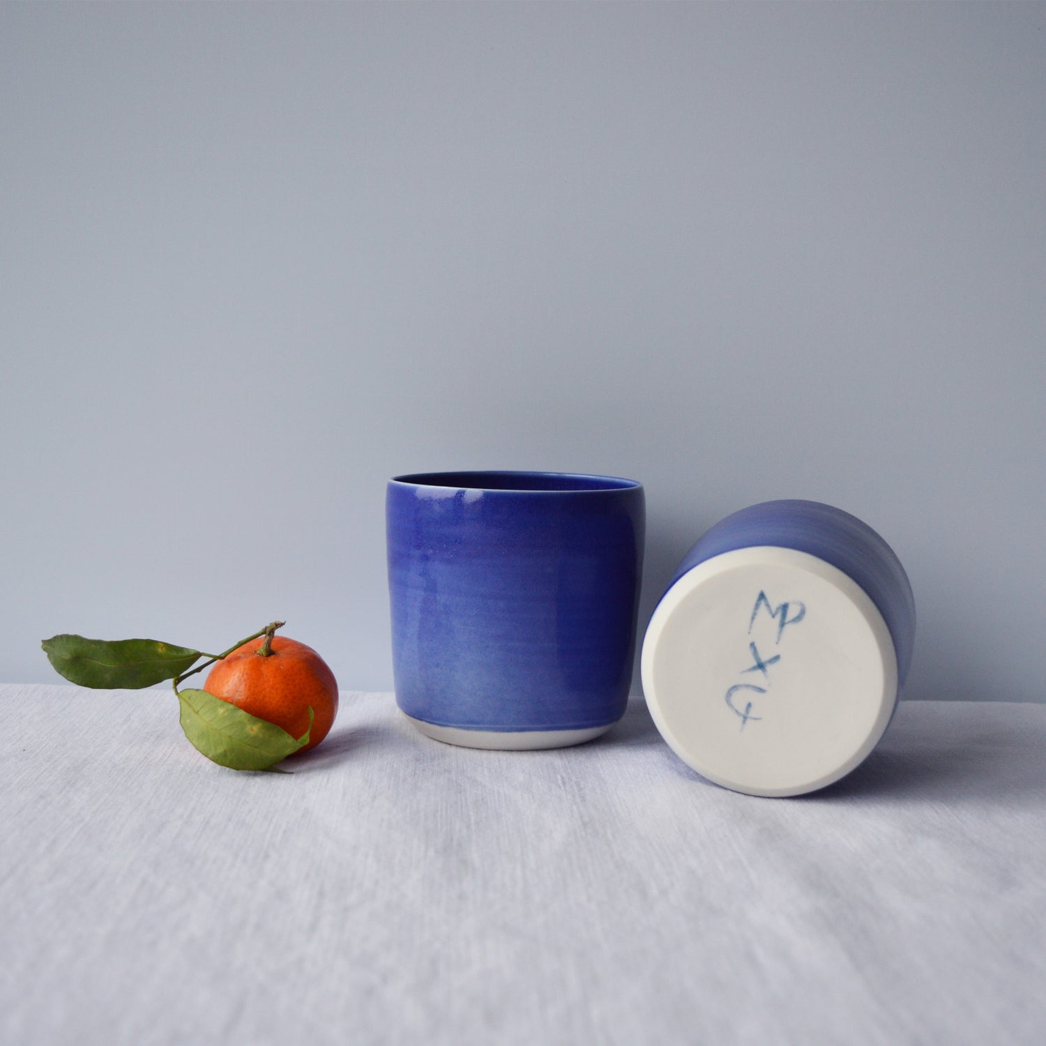 Porcelaine artisanale fabriquée en France, tasses à thé bleues Maison Primavera sur fond blanc.