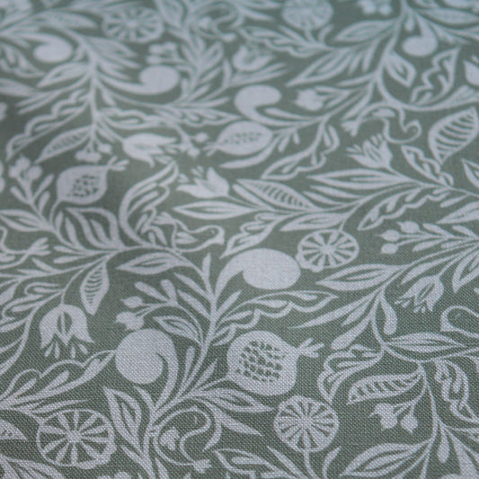 Zoom sur tissu en coton et en lin fabriqué en France dans les Vosges, motif blanc sur fond vert, floral, Alsace