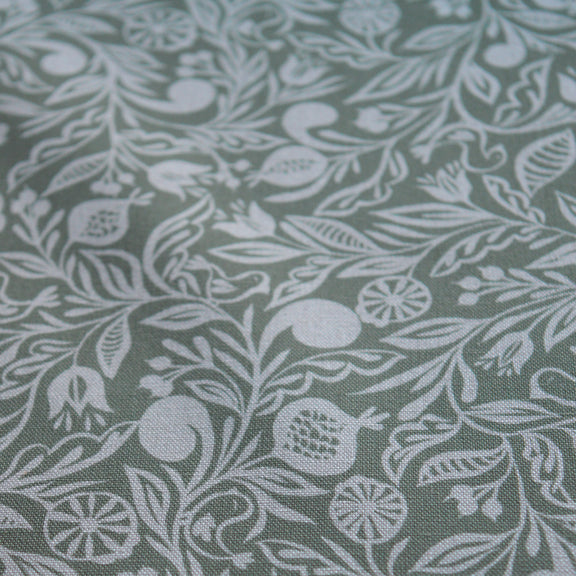 Zoom sur tissu en coton et en lin fabriqué en France dans les Vosges, motif blanc sur fond vert, floral, Alsace