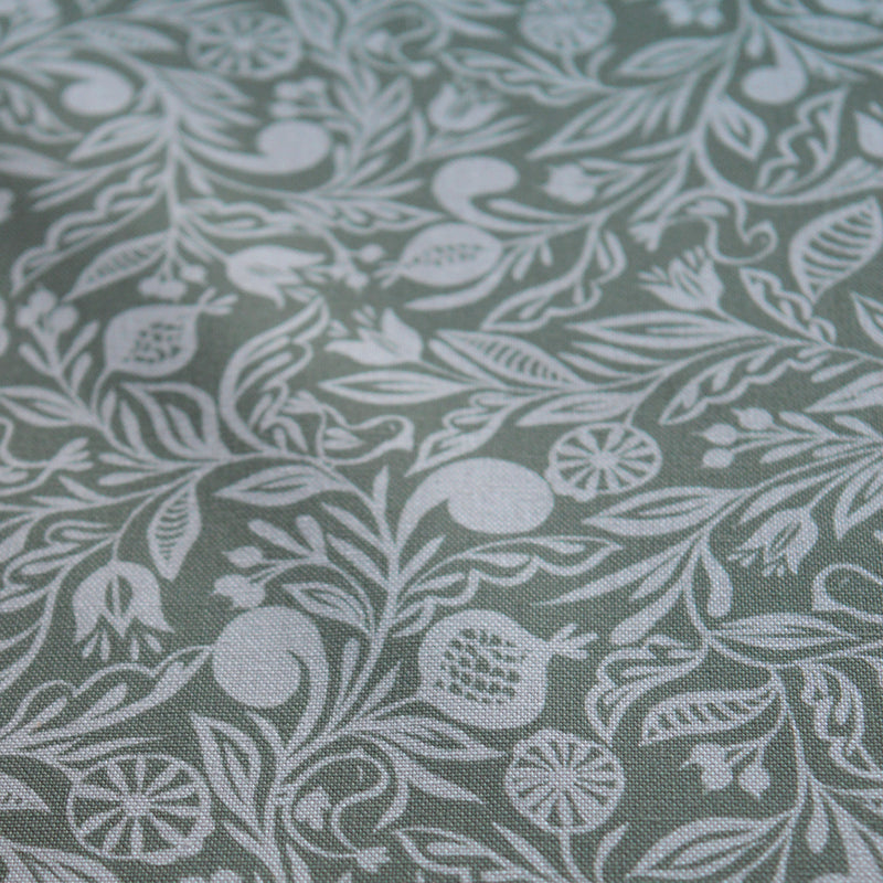 Zoom sur tissu en coton et en lin fabriqué en France dans les Vosges, motif blanc sur fond vert, floral, Alsace