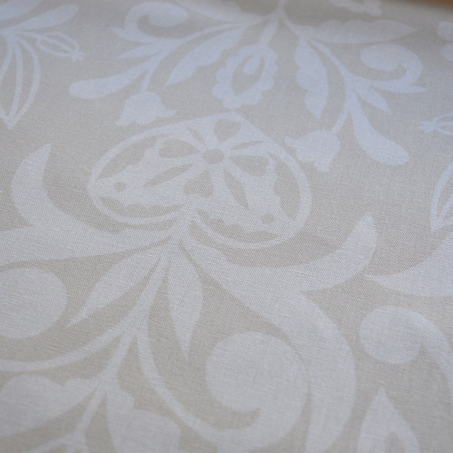 Zoom sur tissu en coton et en lin fabriqué en France dans les Vosges, motif arbre de vie alsacien, blanc sur fond beige, cœur alsacien