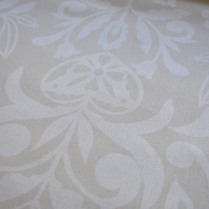 Zoom sur tissu en coton et en lin fabriqué en France dans les Vosges, motif arbre de vie alsacien, blanc sur fond beige, cœur alsacien