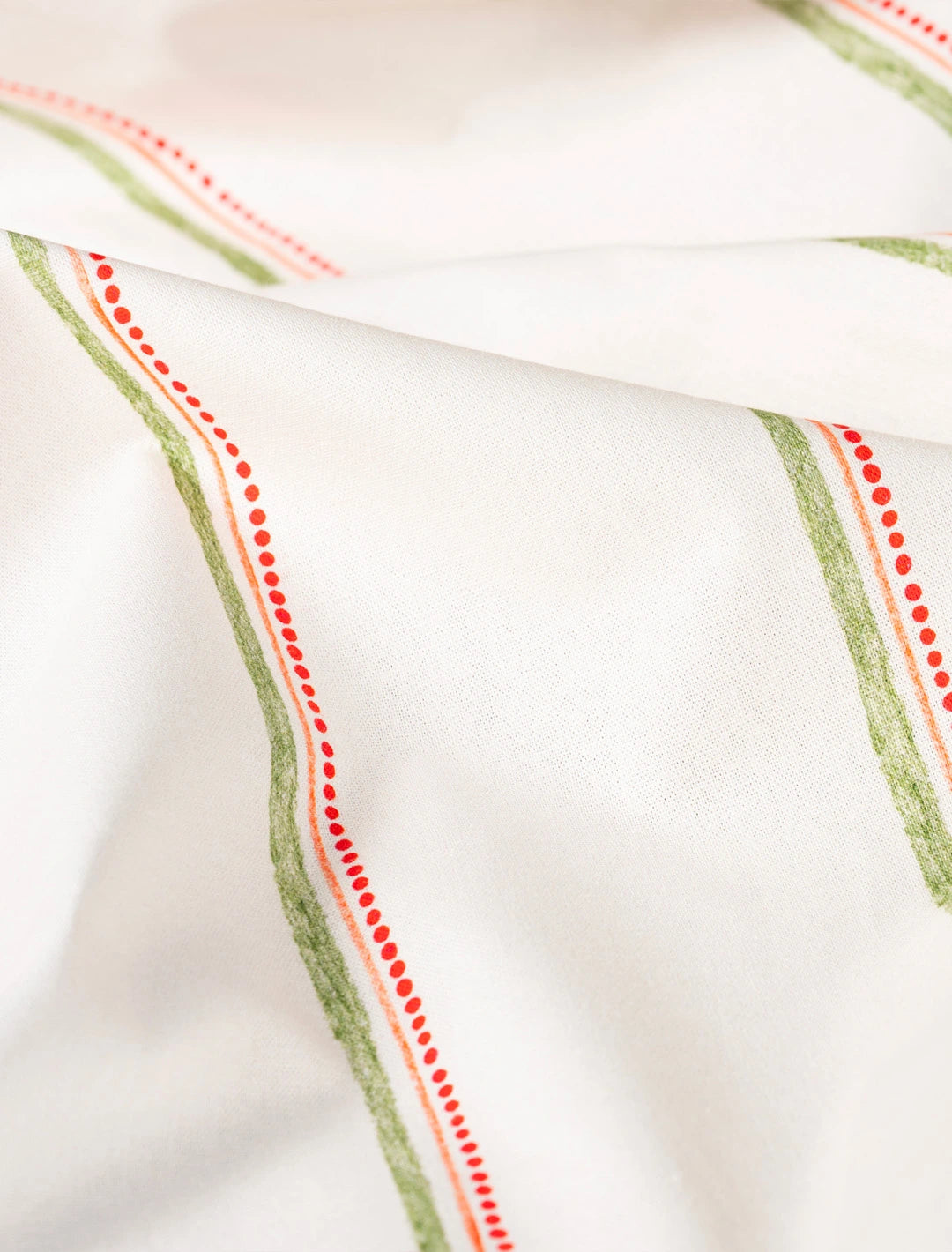 Tissu au mètre en coton et lin fabriqué en France, imprimé avec un motif de rayures vertes, oranges et rouges